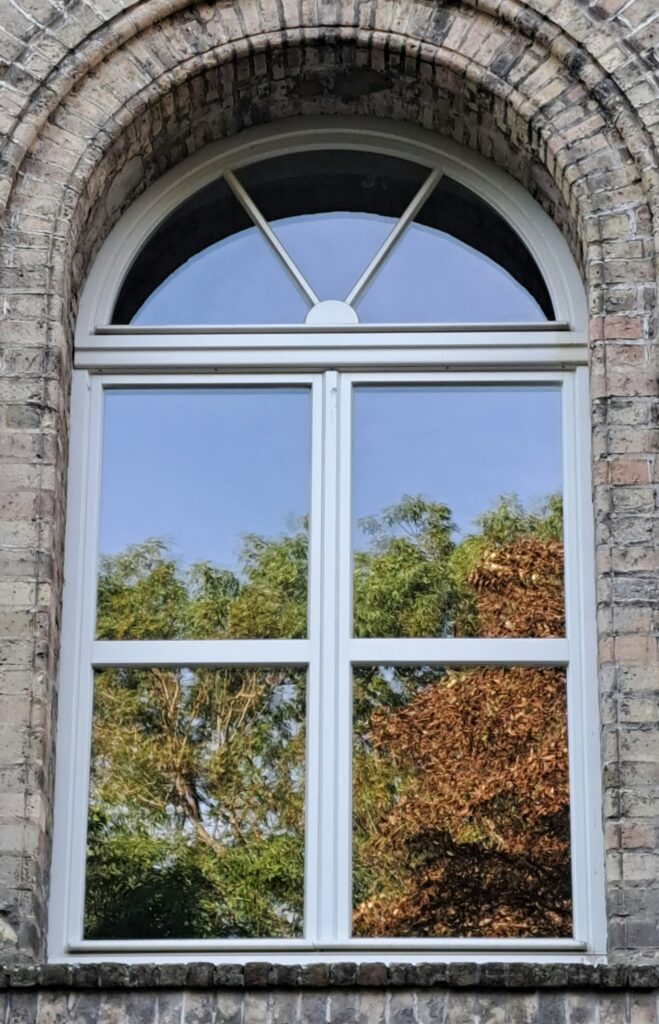 A tilt and turn window on a stone siding house