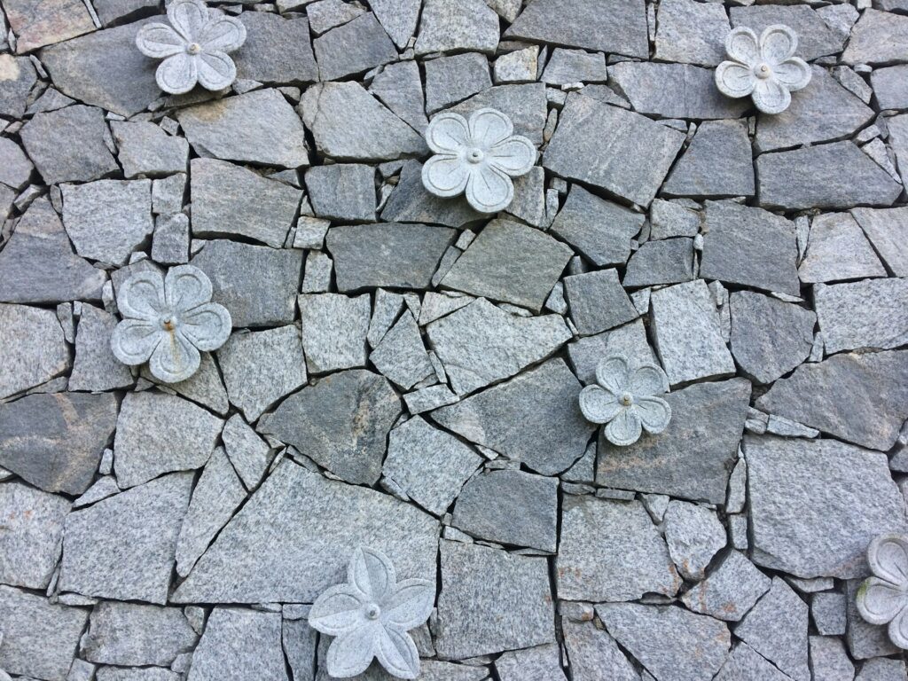 Beautiful stone wall with flowers thanks to stone veneer installation manual