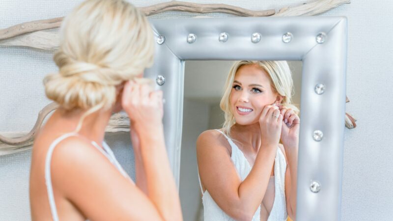 A woman who looking herself in mirror and ask herself: Can Microneedling Replace the Gym for Your Skin?